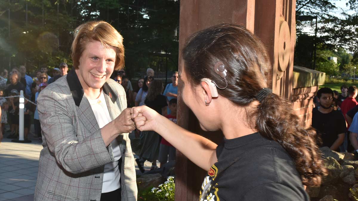 President Jebb fist bumping a student during СƵ's welcome Arching ceremony